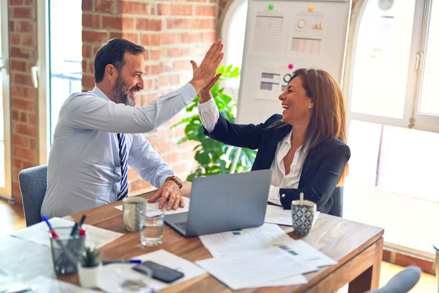 Apretón de manos entre dos profesionales que simboliza el equilibrio multidireccional entre inversionistas y usuarios finales en un sistema empresarial eficiente